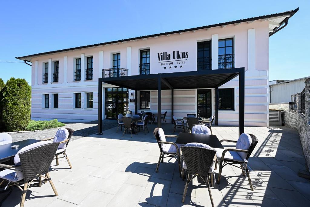 a patio with tables and chairs in front of a building at Boutique Hotel Ukus in Tešanj