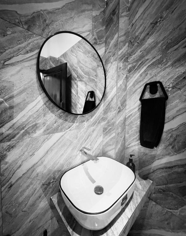 a bathroom with a white sink and a mirror at Blue Wings Arugam Bay in Arugam Bay