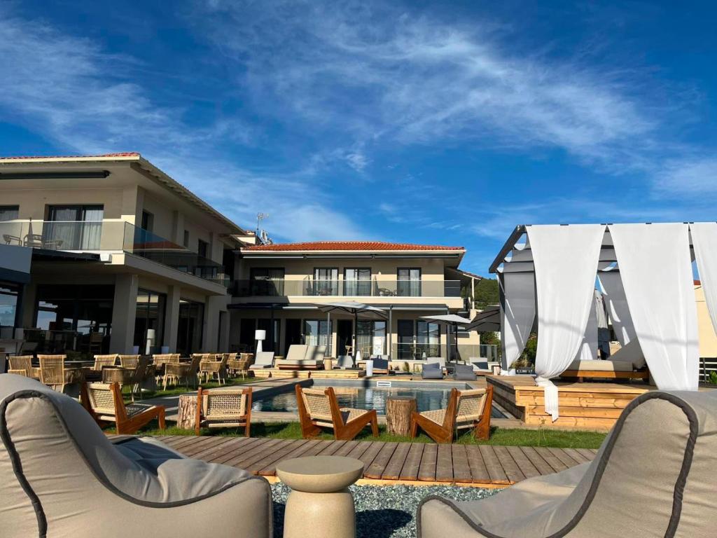 a resort with a pool and chairs and a building at SunSet Boutique Hotel in Neos Marmaras