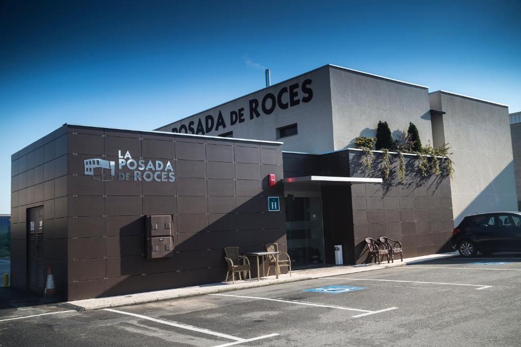 ヒホンにあるHotel la Posada de Rocesの駐車場に車が停まっている建物