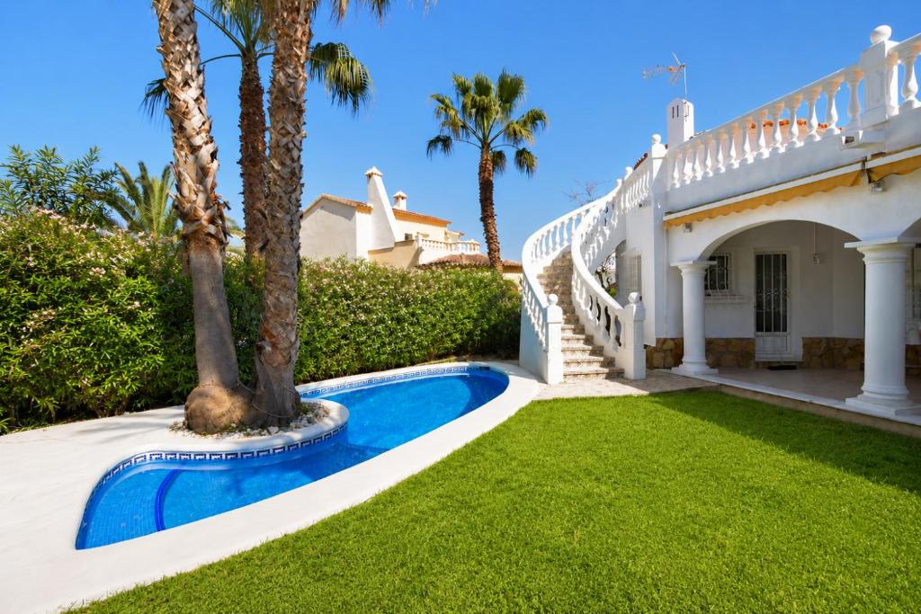 a villa with a swimming pool and palm trees at Villa Renoir by Goveralia in Oliva