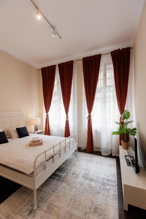 a bedroom with a large bed with red curtains at #Artistic Flat 2BR Historical Center Timișoara in Timişoara