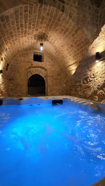 a large blue swimming pool in a stone tunnel at Domus Fidias in Rhodes Town