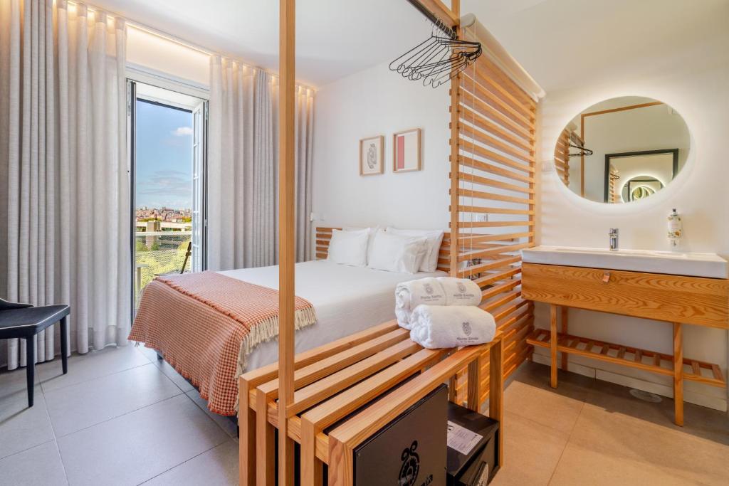 a bedroom with a bed and a sink and a mirror at FONTE SANTA Manor House in Vila Nova de Gaia