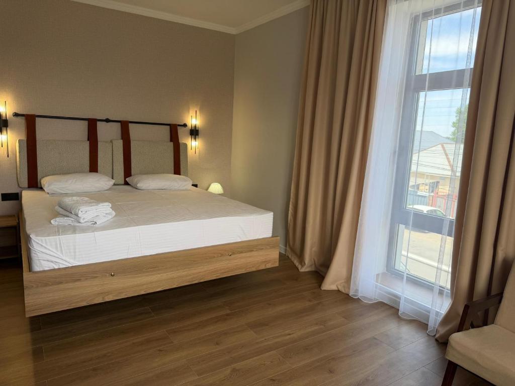 a bedroom with a bed and a large window at Jetel Boutique Hotel in Almaty