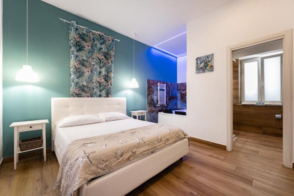 a bedroom with a white bed and blue walls at Aroma Rooms Procida in Procida