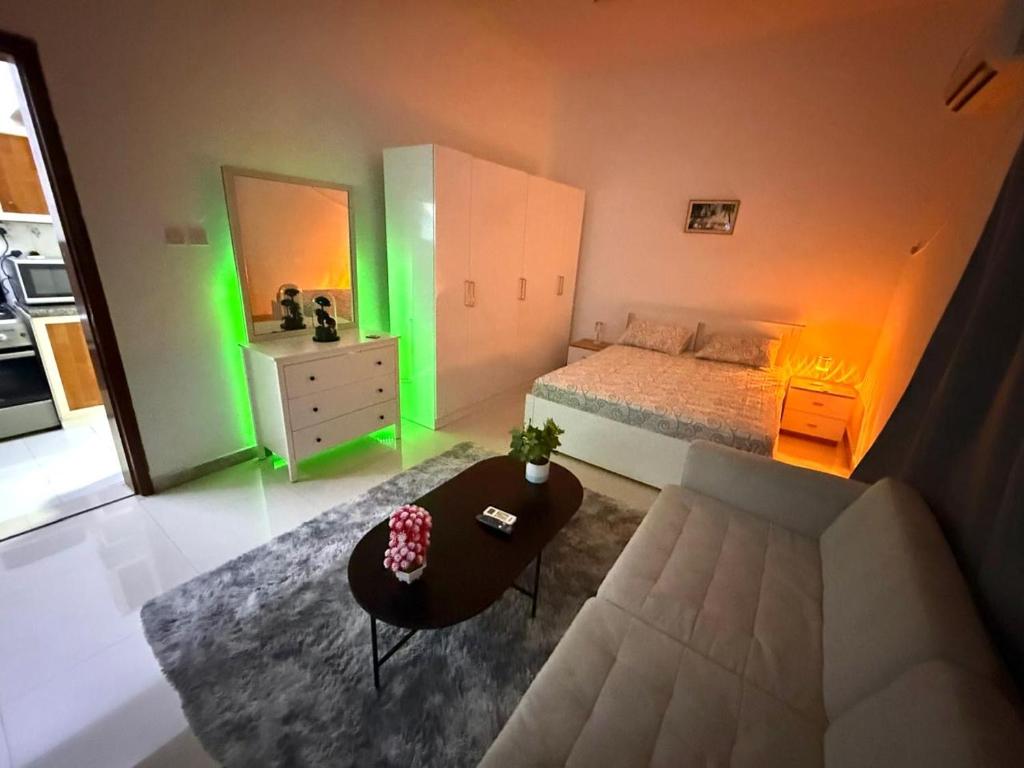 a bedroom with a bed and a table and green lights at المرور ابو ظبي in Abu Dhabi
