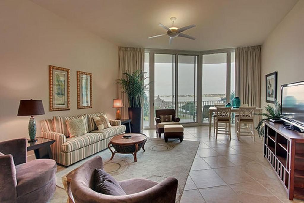 a living room with a couch and a tv at Caribe Resort Unit C101 in Orange Beach