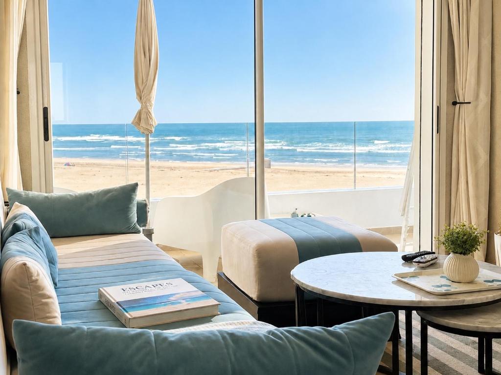 a living room with a view of the beach at Ocean Therapy in Dar Oulad Hajj Kassem