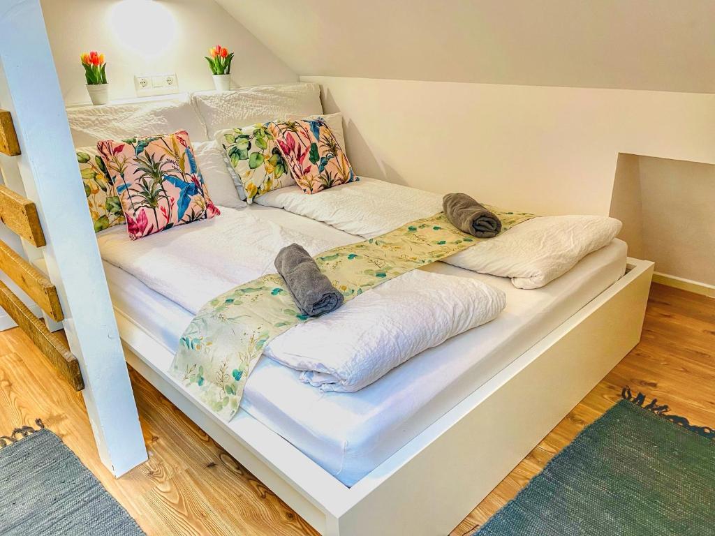 two beds with pillows on them in a room at Magenta Apartman in Mórahalom