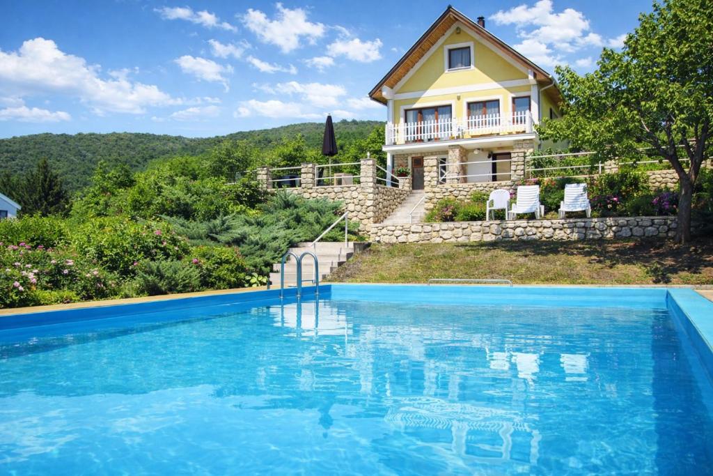 a house with a swimming pool in front of a house at Villa Sümeg in Sümeg
