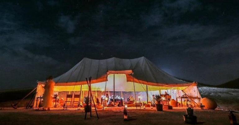 a large tent is lit up at night at Agafay Camping in Aït Daoud