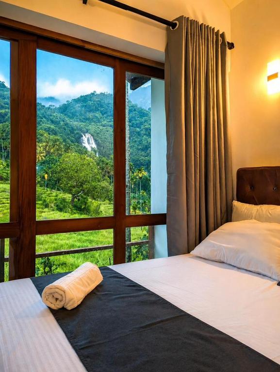 a bedroom with two beds and a large window at Visari Fall Villa Ella in Ella