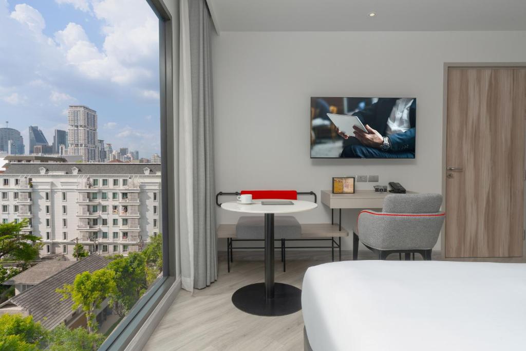 A window-side work and dining nook overlooking Bangkok rooftops.