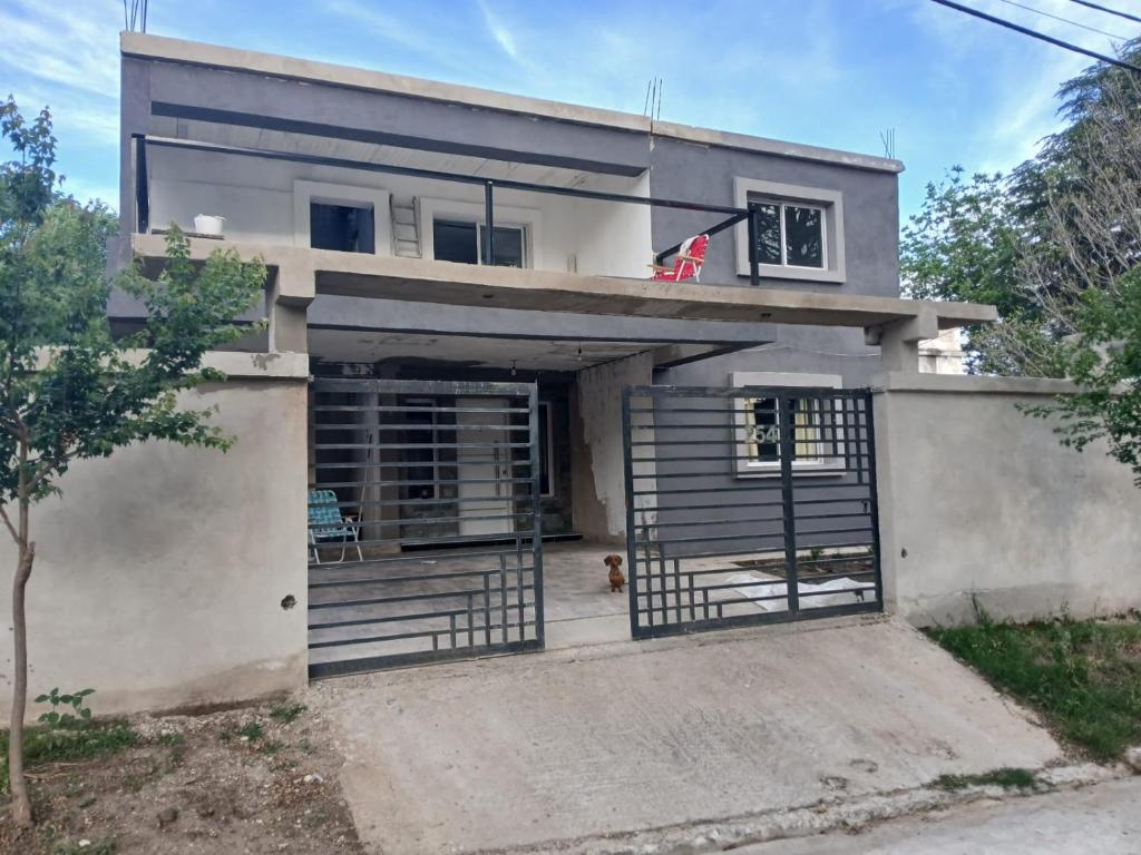 a house with a dog sitting in the front yard at cabañas cosquin in La Porteña