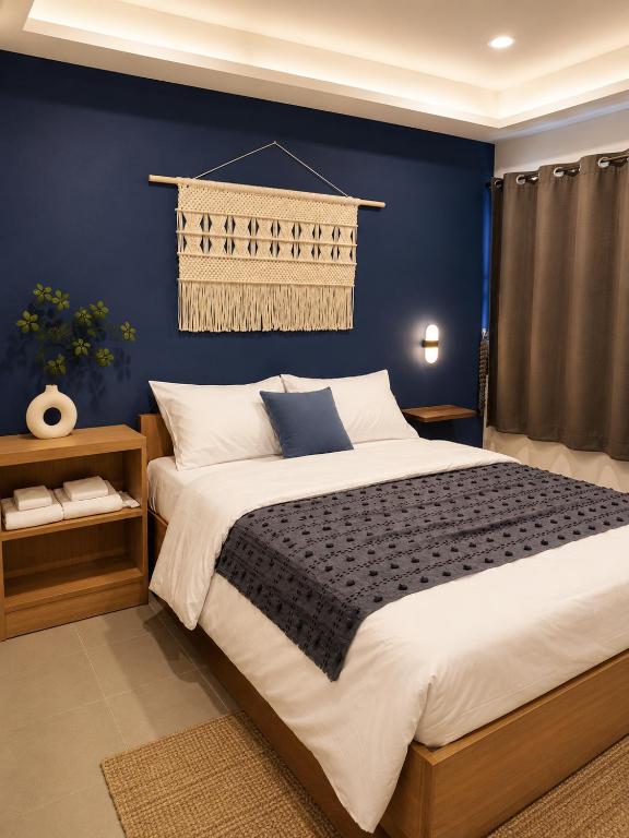a bedroom with a large bed with a blue wall at La Vie Résidence in Chiang Mai