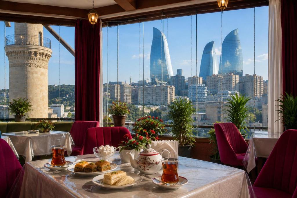 a table in a restaurant with a view of the city at Old Town Hotel in Baku