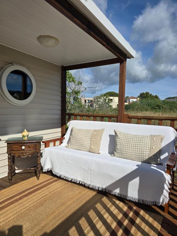 a bed on a deck with a table at Maria Meco in Sesimbra