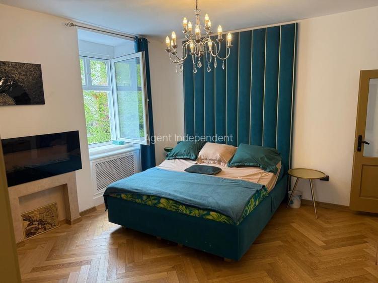 a bedroom with a bed with a green headboard at Downtown luxury segment in Braşov