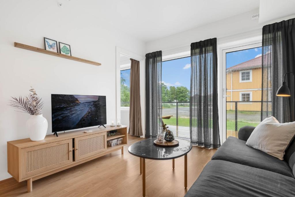 a living room with a couch and a tv at Helt ny leilighet in Leknes