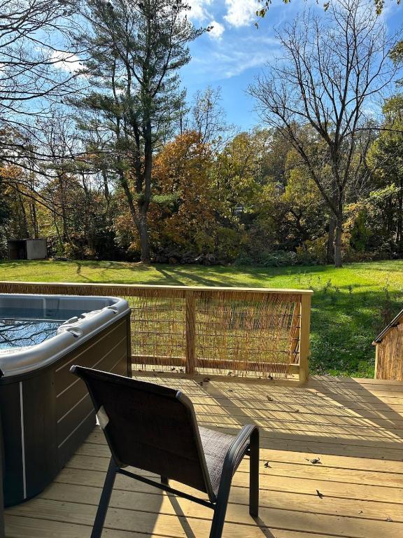 a chair sitting on a deck next to a hot tub at Cabin Oasis near Town in Catskill
