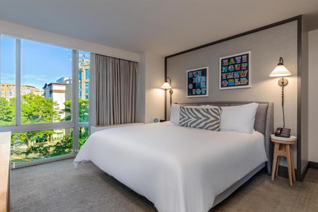 a bedroom with a white bed and a large window at The Beacon at Embassy Row, WorldHotels Distinctive in Washington, D.C.