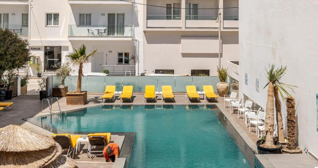 a swimming pool with lounge chairs and a hotel at 4BR Newly Renovated Retreat Tranquil Coastal Haven in Hersonissos