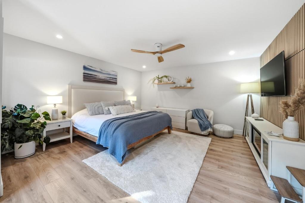 a bedroom with a bed and a flat screen tv at Low Tide Suite - Modern, Oceanside Suite with King Bed, Resort Pool & Hot Tub in Nanoose Bay