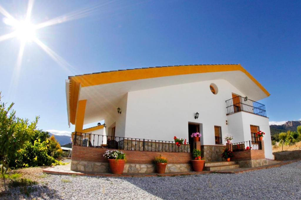 una pequeña casa blanca con macetas delante de ella en Alojamiento Rural Sierra de Castril, en Castril