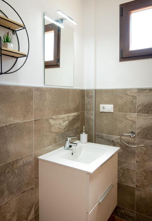 a bathroom with a white sink and a mirror at Hostal Papi in Zafrilla