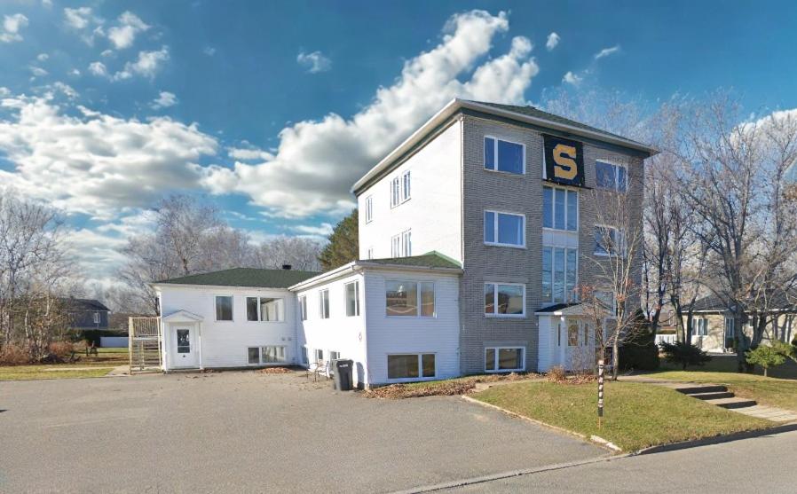 a large white building with the s on it at Maison de chambres - Édifice Le SAGE in Shawinigan