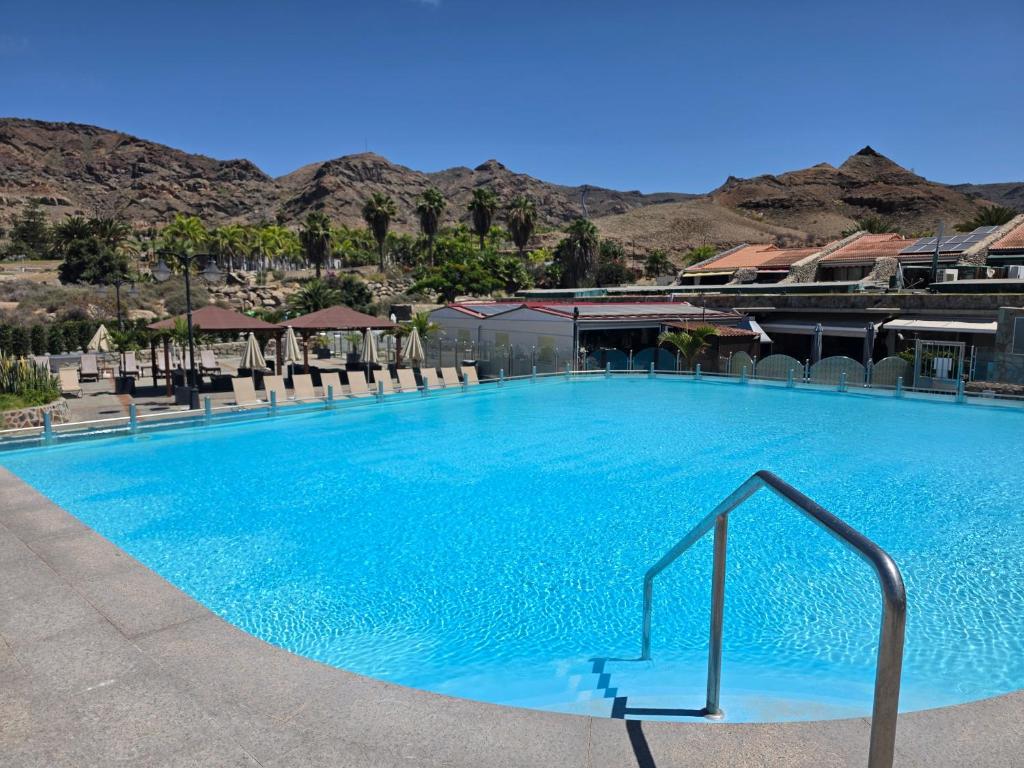 a large blue swimming pool with mountains in the background at Villa Torbellino, Diseño, Privacidad y Confort in La Playa de Tauro