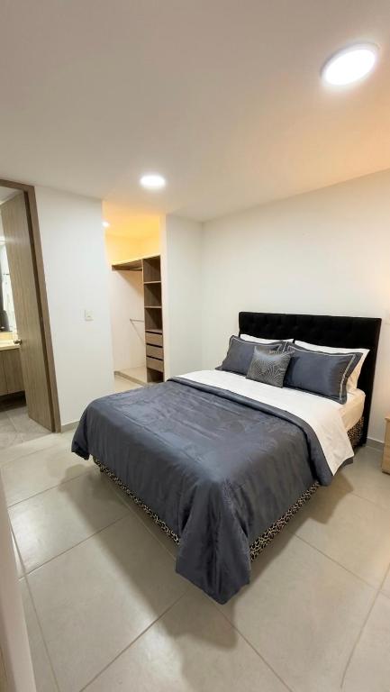 a bedroom with a large bed with blue pillows at Apartamento Vergel in Ibagué