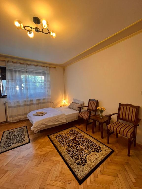 a bedroom with a bed and two chairs and a table at Apartman 23 in Kraljevo