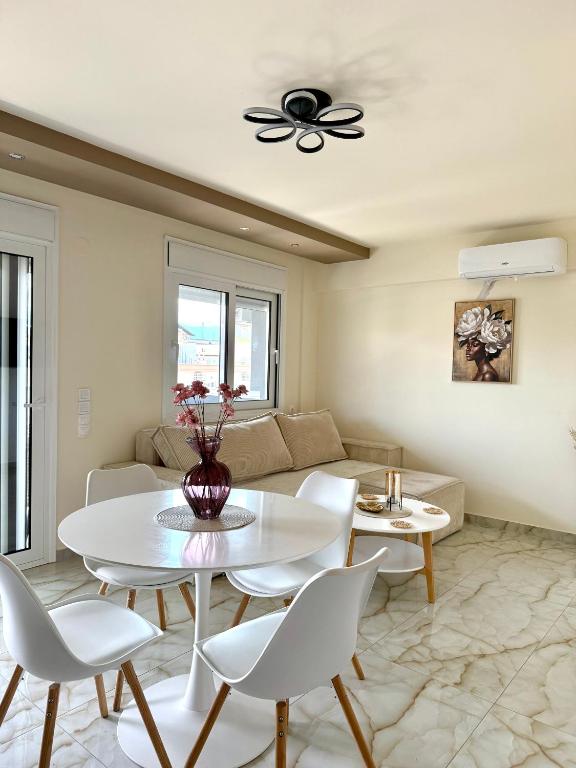 a living room with a white table and chairs at Malama Rooms in Paralia Katerinis