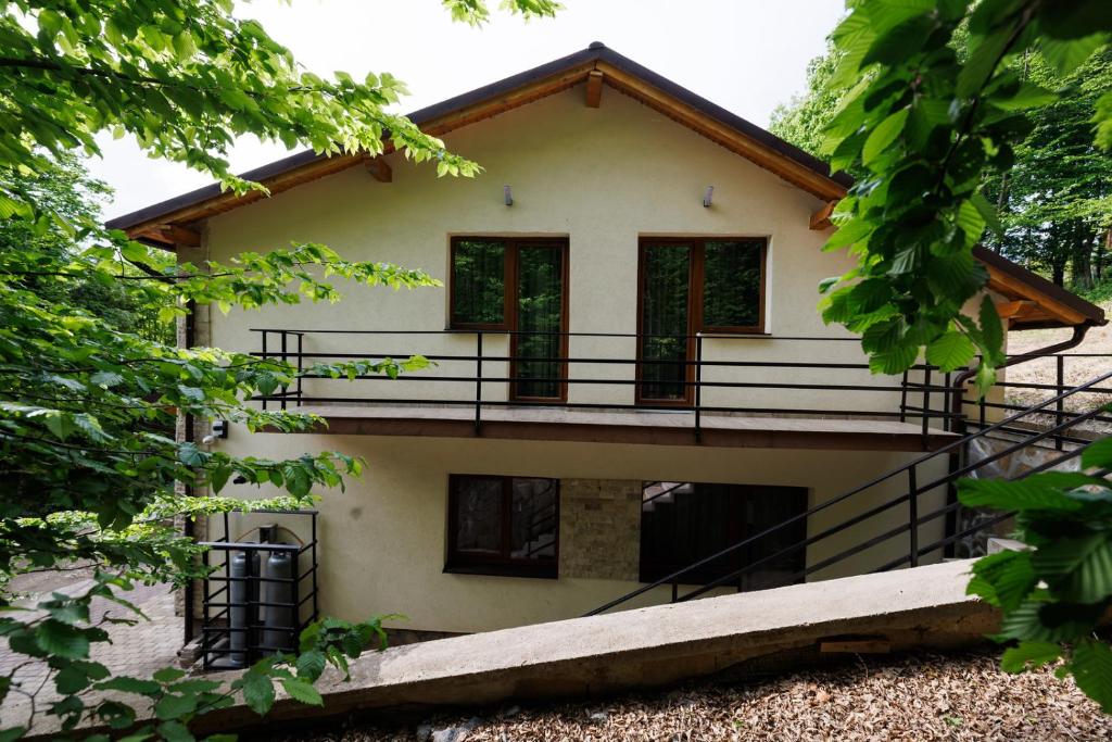 a house with a balcony on the side of it at Vila MIHAI in Văliug