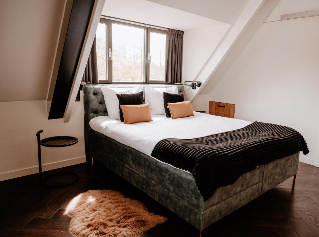 a bedroom with a bed with white sheets and pillows at Hotel La Boutique in Nijmegen