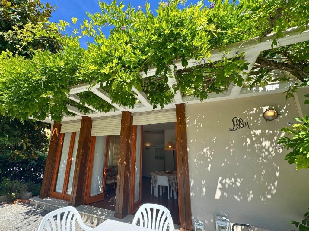 a patio with white chairs and a table at Villa Lilly in Grado