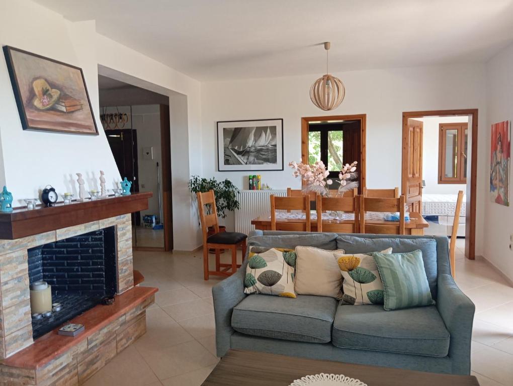 a living room with a couch and a fireplace at Stamoulis Garden House in Katigiorgis