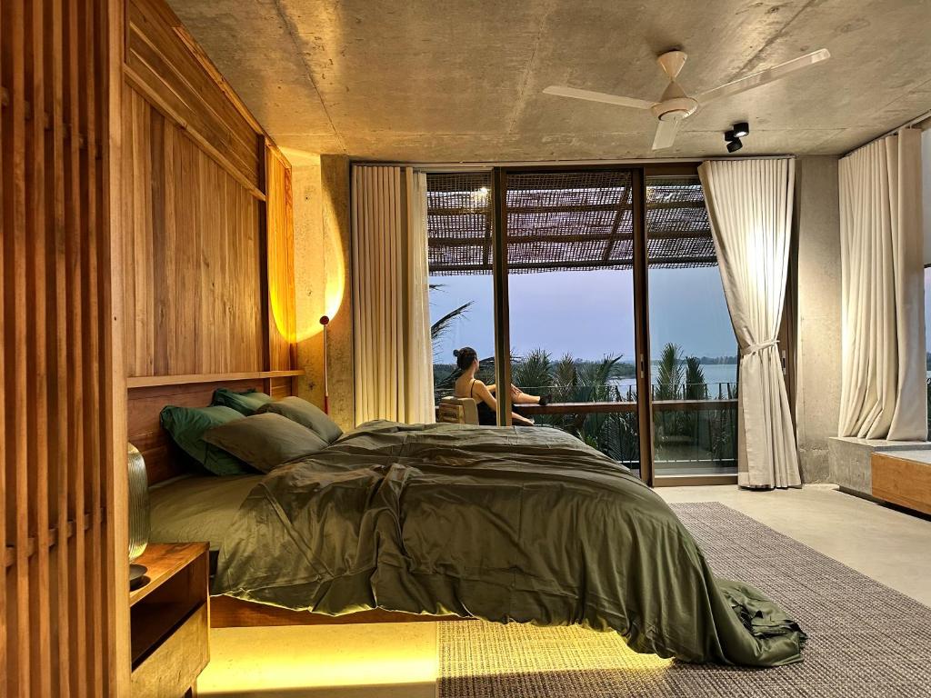 a bedroom with a bed and a large window at Chum Home in Thanh Ðông (1)