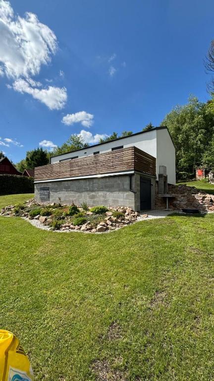 a building with a grass field in front of it at Sedlinka Klíny in Klíny