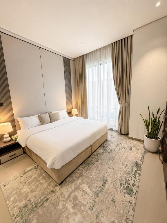 a bedroom with a large bed and a large window at Ghosen Al Zaitoon chalet in Sayq