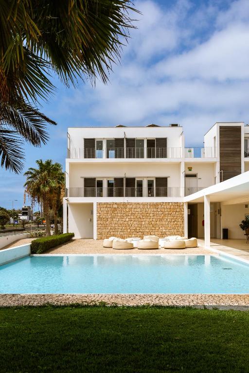 a house with a swimming pool in front of a building at Hotel Dunas de Sal in Santa Maria