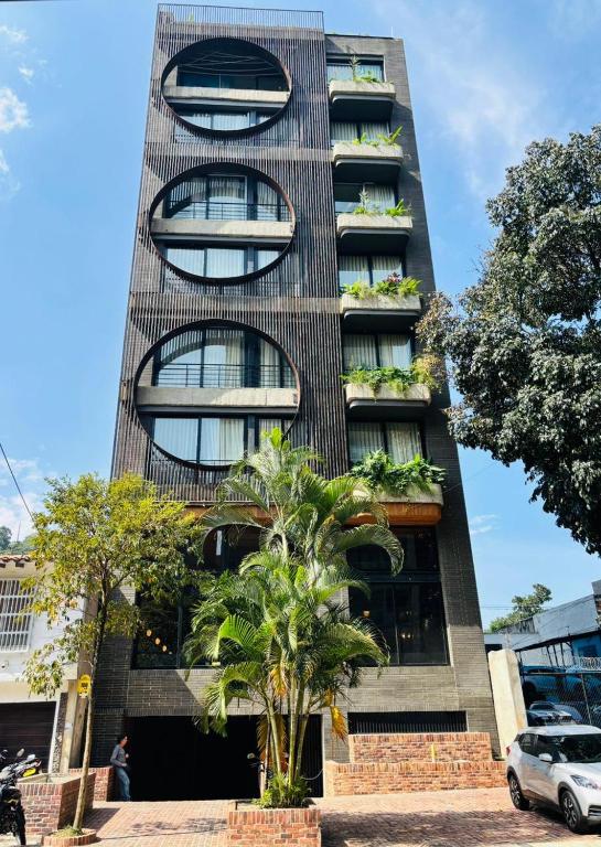 a tall building with a palm tree in front of it at Iconik Hotel in Medellín
