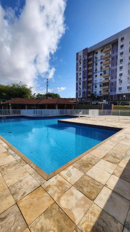 a large blue swimming pool in front of a building at Apartamento Park Vinhais in São Luís