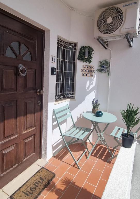 a room with a table and a chair and a door at Casa Farol View in Carvoeiro