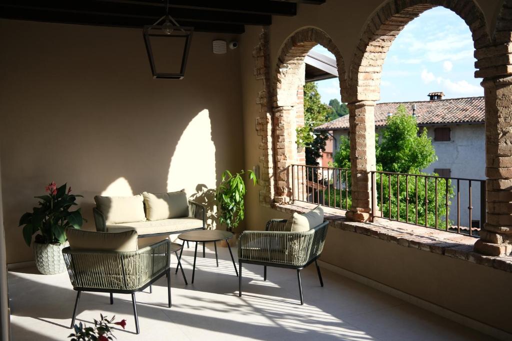 a patio with chairs and a couch on a balcony at L'Upupa Bed & Breakfast in Muscoline