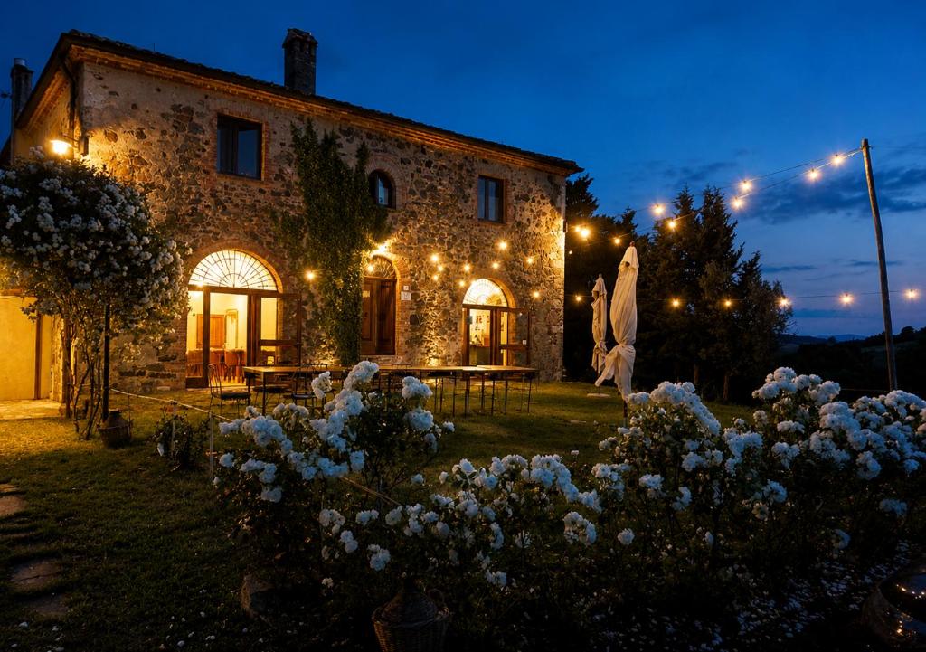 a stone house with lights in front of it at Il Cerchio delle Streghe Country House al Podere Casella in Castiglione dʼOrcia