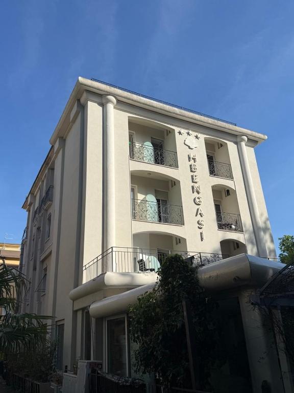 a large white building with a balcony at Hotel BENGASI Marina Centro in Rimini