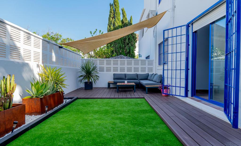 a patio with a couch and green grass at Casa Dracaena in San José